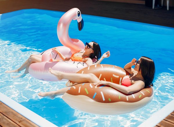 Girls on summer party in the swimming pool Beautiful girls on a vacation. Friends in the swimming pool